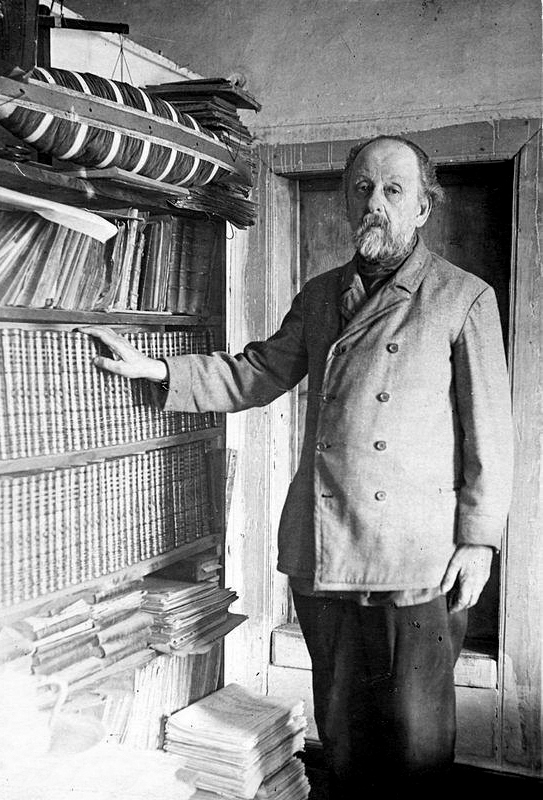 К.Э. Циолковский в рабочем кабинете у полки с книгами.
